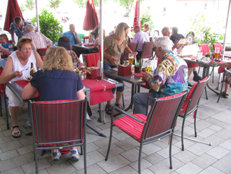 Gruppe sitzt im Bistro vor dem Roten Ross